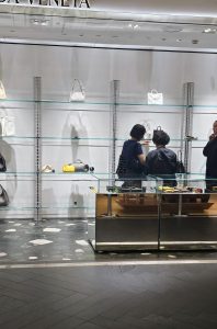 Luxury boutique client taking time to explore products with a sales advisor before making a purchasing decision.